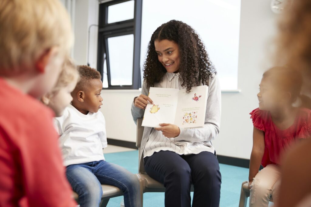 Enseignante montrant un livre aux enfants de la maternelle