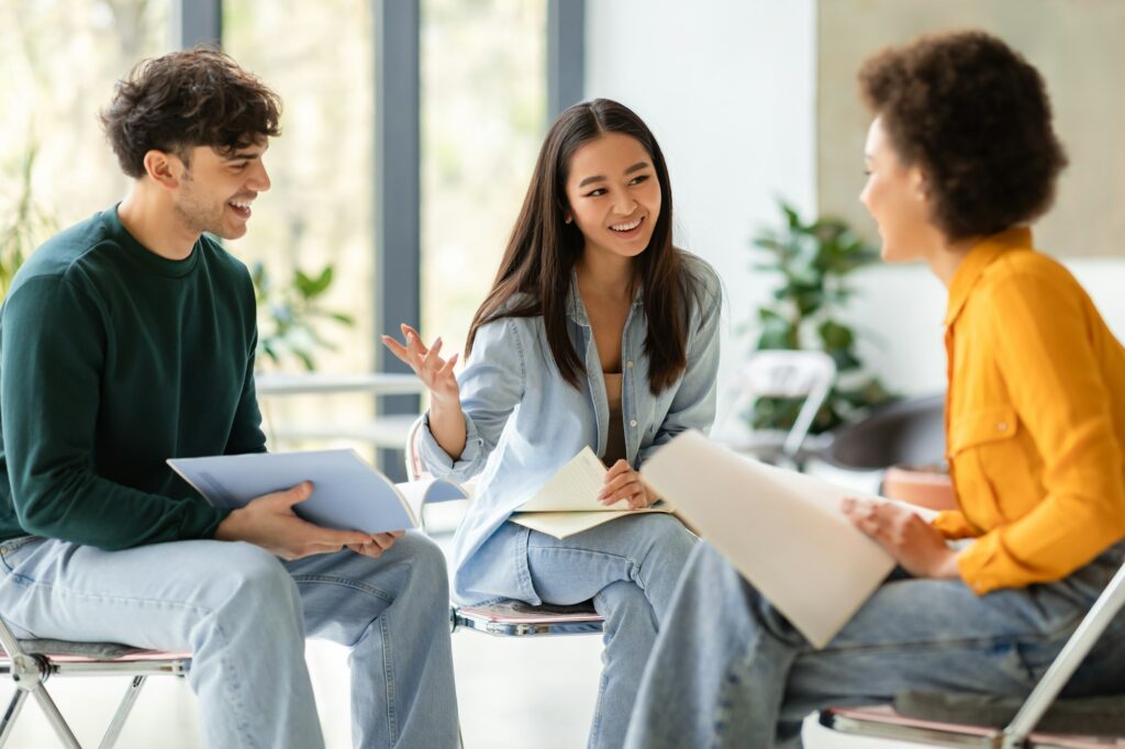 Multiracial students discussing notes in lively group study session