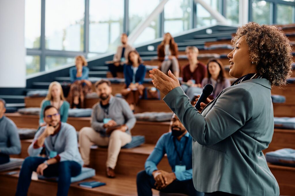 Female speaker talking on a business conference at convention center.