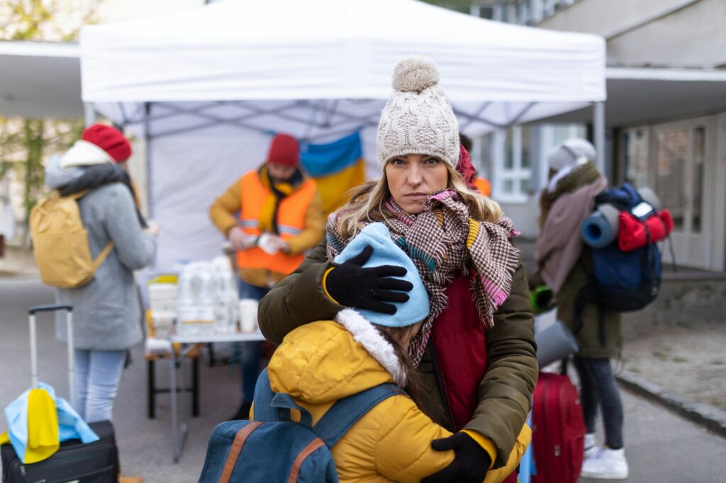 Ukrainian refugee mother with child crossing border and looking at camera